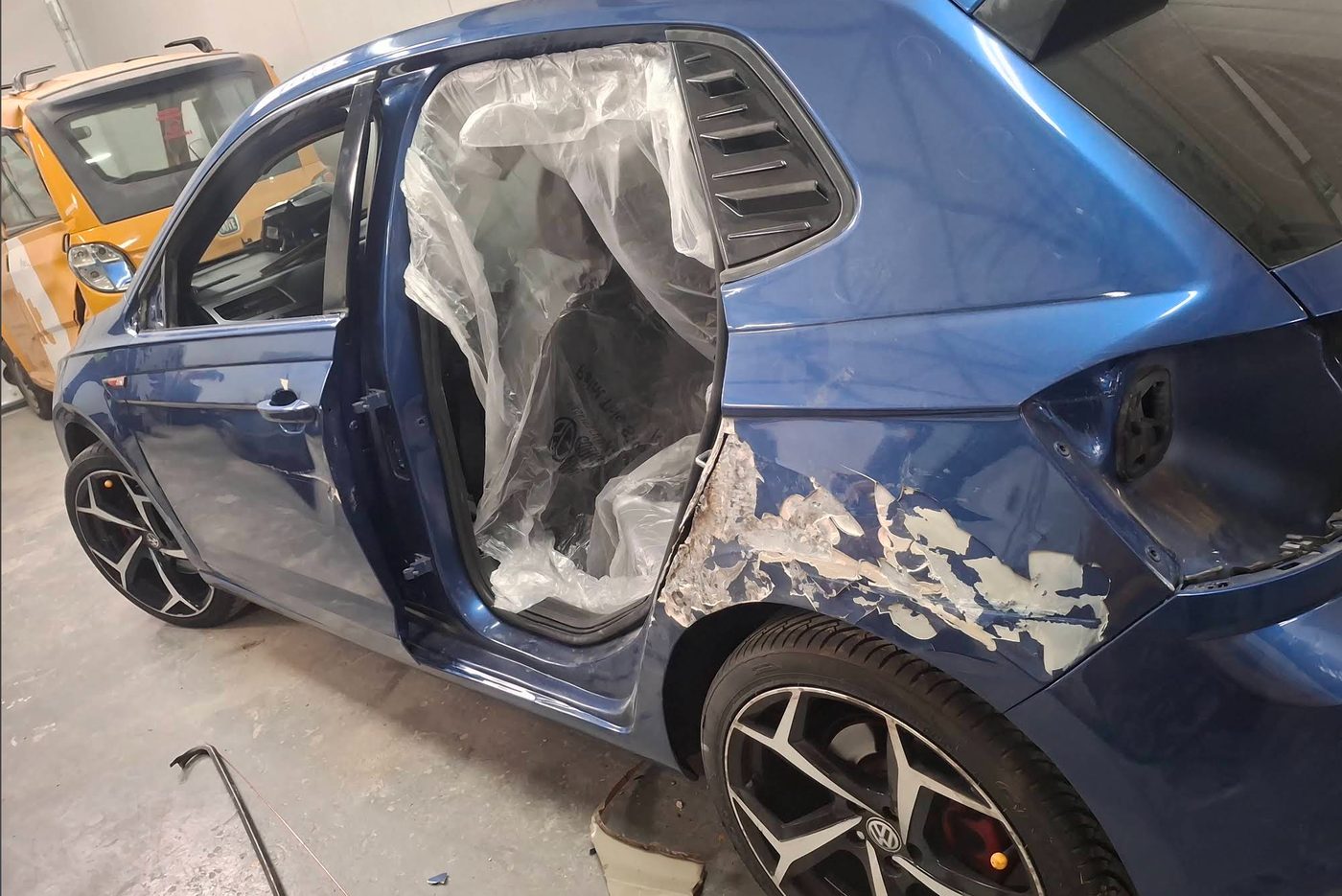 Blue VW Polo GTI before repair: rear door removed and the rear quarter panel stripped to filler